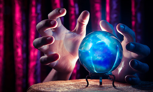 Hands around a crystal ball, with light emitting from it.